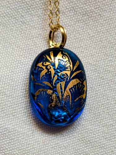 Blue charm with golden accent